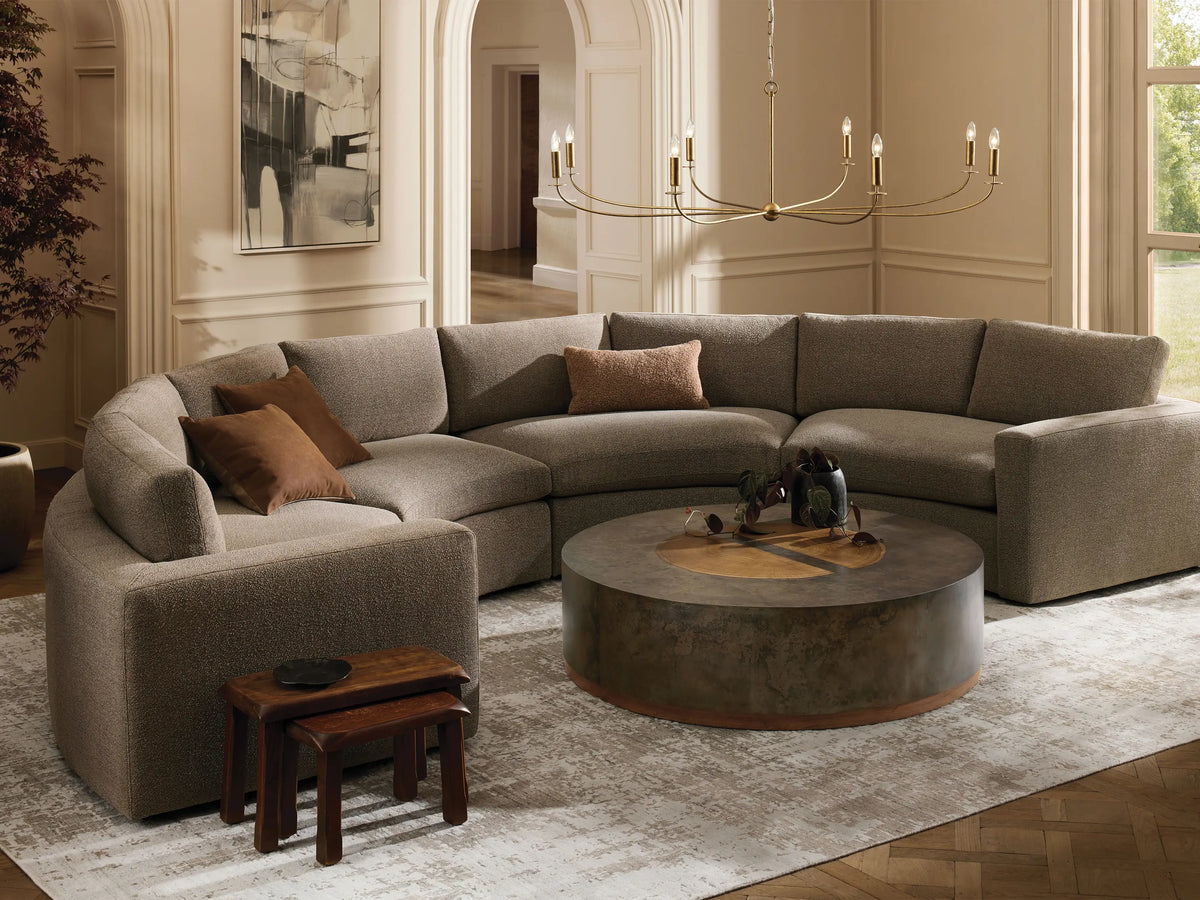 Beale Four-Piece Curved Sectional, U-shaped in textured gray fabric, with brown accent pillows, in a cozy, bright living room.