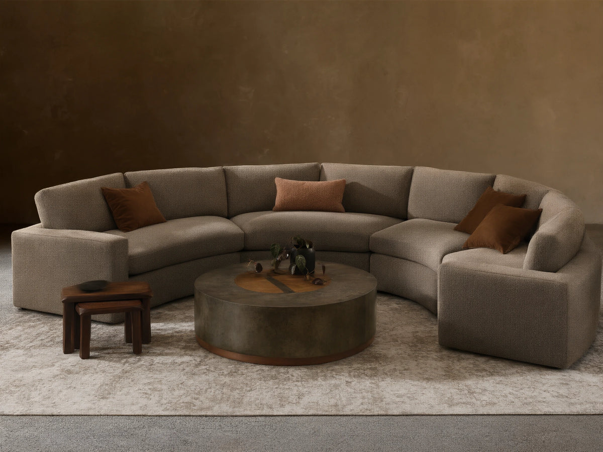 Beale Four-Piece Curved Sectional, U-shaped in textured gray fabric, with brown accent pillows, in a cozy, bright living room.