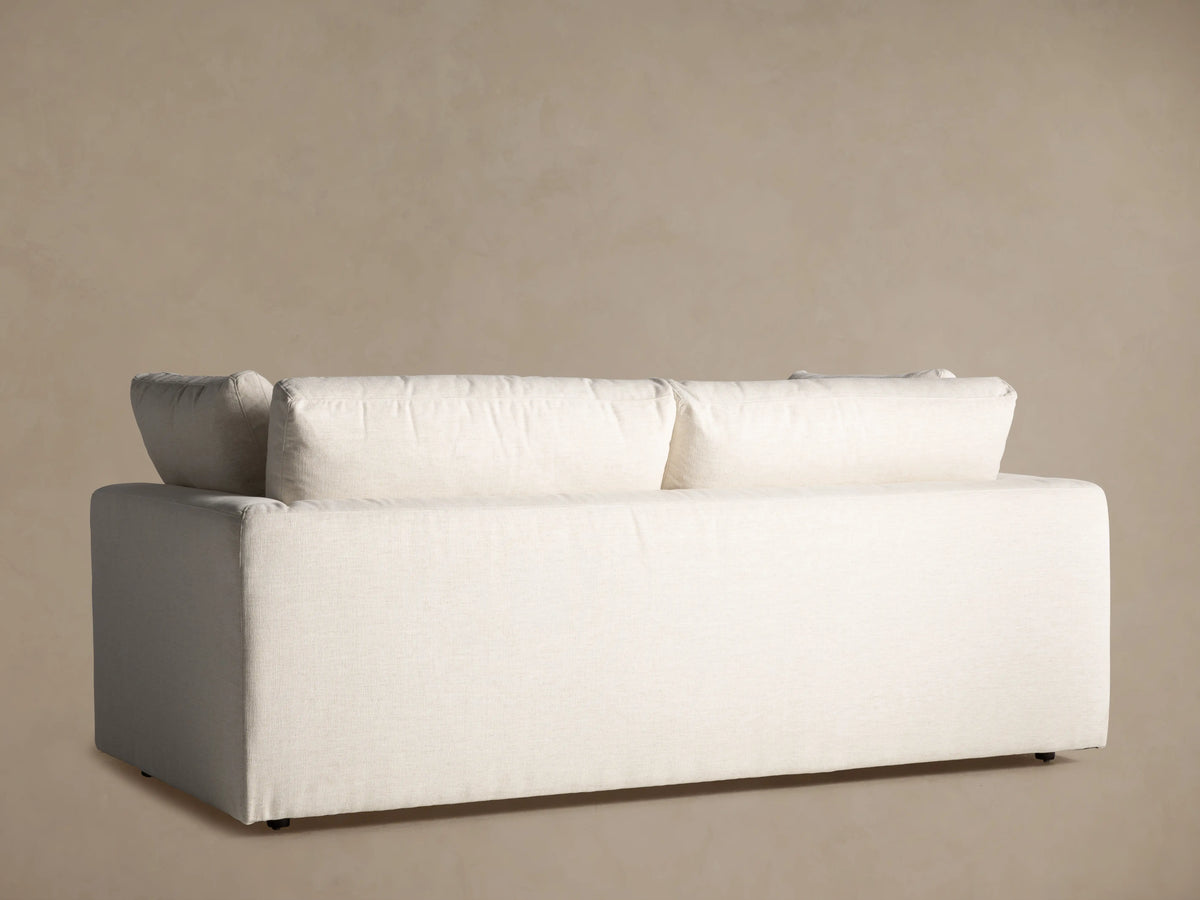 Close-up of the light beige textured fabric on the armrest, seat, and back cushions of the Beale Sofa.