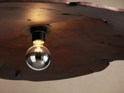 Arruga Chandelier with an irregular dark wood shade, exposed silver bulb, suspended by thin black cables and white cord.