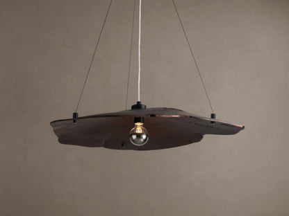 Arruga Chandelier: Dark brown, organic milpa wood dome, suspended by black cables, with a softly glowing bulb.